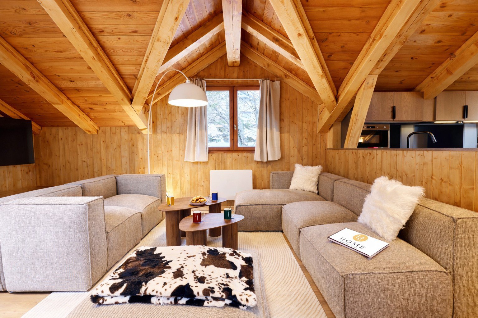 Coin salon du chalet Titania à Courchevel avec canapés modulables et plaid motif vache
