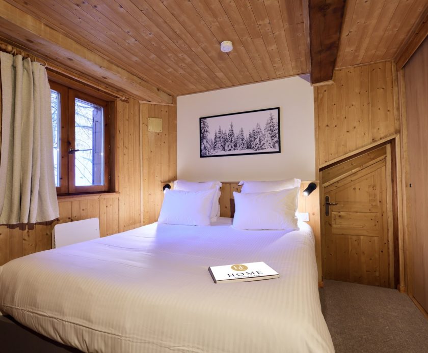 Chambre cosy du chalet Titania à Courchevel avec boiseries et lit double