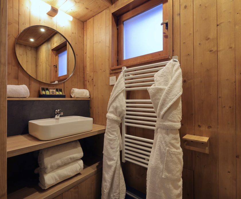 Salle de bain du chalet Titania à Courchevel avec vasque en bois et peignoirs